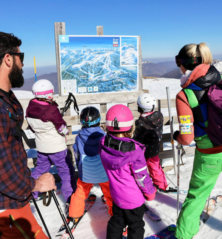 Les stations de ski Famille regardant le plan des pistes - Image colorée, bonheur partagé, bons moments au mourtis débutants-en-ski